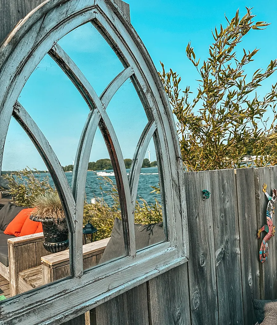 Het houten boograam op het terras met het meer erachter