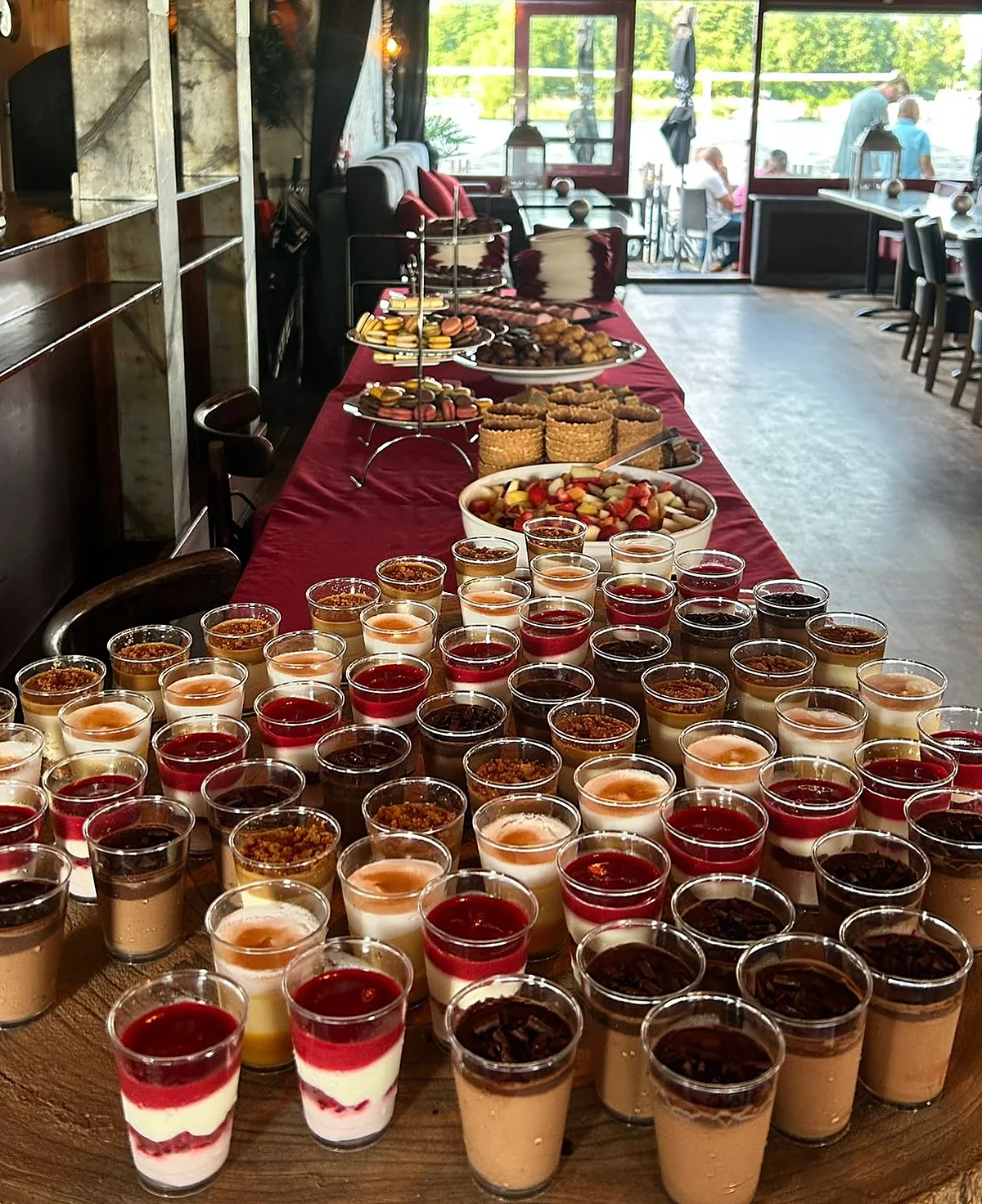 Een lange tafel vol desserts in glaasjes